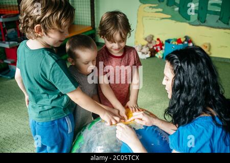 Les enfants apprennent sur les pays avec un ballon gonflable de globe Banque D'Images