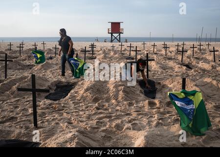 Rio de Janeiro, Brésil. 11 juin 2020. Les activistes de l'ONG Rio de Paz creusent des tombes sur la plage de Copacabana pour symboliser les victimes de Corona dans une protestation contre la gestion de la crise par le gouvernement. Le Brésil est le pays le plus touché en Amérique latine par la pandémie du virus corona. Crédit : Ian Cheibub/dpa/Alay Live News Banque D'Images