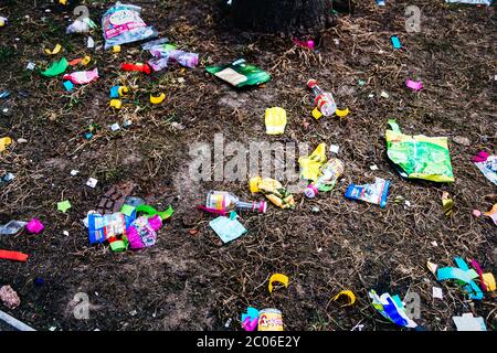 Des emballages de chocolat vides, des décorations de festival et d'autres ordures en plastique coloré sont couchés dans la rue après le traditionnel grand défilé de carnaval Banque D'Images