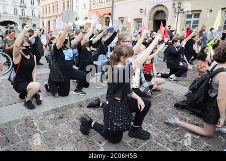 Les manifestants s'agenouillent et tiennent leurs poings pendant la manifestation « Black Lives Matter » à Cracovie, la plus grande ville du sud de la Pologne. Les manifestants ont payé le prix de la trib Banque D'Images