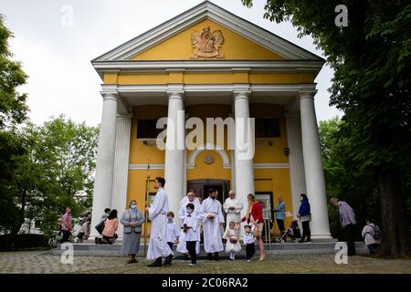 Un serveur d'autel tenant une énorme croix à la paroisse de la Sainte Vierge Marie de Czestochowa à la rue Kochanowskiego pendant la procession.la Fête du corps et du sang du Christ (Corpus Christi) Est une fête dédiée à la vénération du corps et du sang du Christ, dans laquelle le pain et le vin sont transformés pendant l'Eucharistie selon la foi chrétienne. Selon la tradition, une procession solennelle est organisée dans les rues de l'Église catholique ce jour-là. En Pologne, ce jour est un jour férié. Cette année, de nombreux participants au cortège portaient des masques médicaux, dont alt Banque D'Images