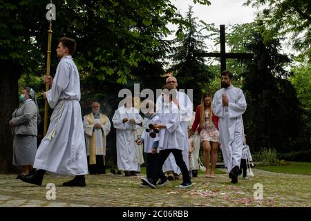 Serveur d'autel des garçons portant des masques de visage à la paroisse de la Sainte Vierge Marie de Czestochowa à la rue Kochanowskiego pendant la procession.la Fête du corps et du sang du Christ (Corpus Christi) Est une fête dédiée à la vénération du corps et du sang du Christ, dans laquelle le pain et le vin sont transformés pendant l'Eucharistie selon la foi chrétienne. Selon la tradition, une procession solennelle est organisée dans les rues de l'Église catholique ce jour-là. En Pologne, ce jour est un jour férié. Cette année, de nombreux participants au cortège portaient des masques médicaux, dont alt Banque D'Images