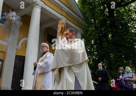 Le prêtre vu à la paroisse de la Sainte Vierge Marie de Czestochowa dans la rue Kochanowskiego pendant la procession.la Fête du corps et du sang du Christ (Corpus Christi) Est une fête dédiée à la vénération du corps et du sang du Christ, dans laquelle le pain et le vin sont transformés pendant l'Eucharistie selon la foi chrétienne. Selon la tradition, une procession solennelle est organisée dans les rues de l'Église catholique ce jour-là. En Pologne, ce jour est un jour férié. Cette année, de nombreux participants au cortège portaient des masques médicaux, y compris des serveuses d'autel et des religieuses. Banque D'Images