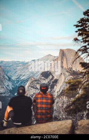 Deux personnes assises sur une rocheuse en admirant la vue sur Half Dome Banque D'Images
