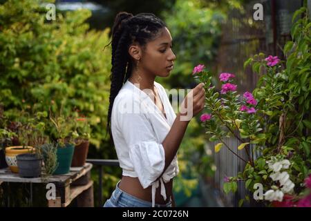 Jeune femme noire qui sent des fleurs Banque D'Images