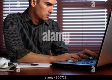 L'homme le travail à domicile sur ordinateur portable Banque D'Images