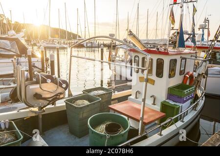 Petit bateau de pêche qui s'ancre dans le port pendant un coucher de soleil pittoresque Banque D'Images