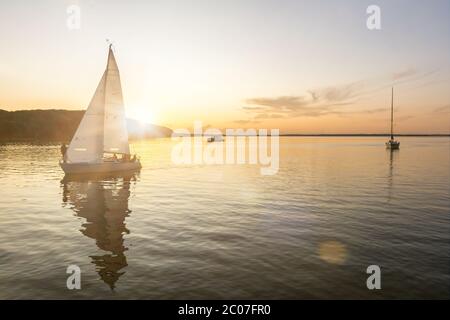 Des bateaux à voile qui reviennent dans le port au beau coucher du soleil sur la mer Baltique Banque D'Images