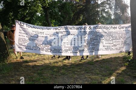 11 juin 2020, Saxe-Anhalt, Dessau-Roßlau: Les participants à une commémoration dans le parc de Dessau tiennent une bannière avec les noms des victimes de la violence extrémiste et raciste de droite en Allemagne de 1990 à 2011 entre leurs mains. Ils se rappellent avec lui le mozambican Alberto Adriano, 39 ans, qui a été battu par les néonazis à Dessau le 11 juin 2000. Il est mort de ses blessures trois jours plus tard. Photo: Sebastian Willnow/dpa-Zentralbild/dpa Banque D'Images