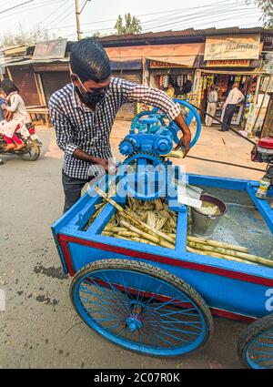 Street Side sugarcane Juice Maker, faisant le jus en écrasant les sucreries. Banque D'Images