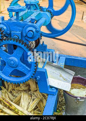 Street Side sugarcane Juice Maker, faisant le jus en écrasant les sucreries. Banque D'Images