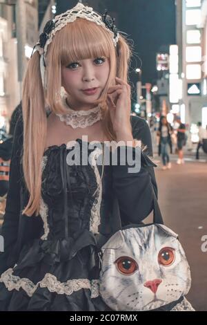 Fille japonaise non identifiée en costume noir et cheveux blond avec corps marchant à Harajuku à Tokyo Japon (exemple de cosplay japonais typique de kawai) Banque D'Images
