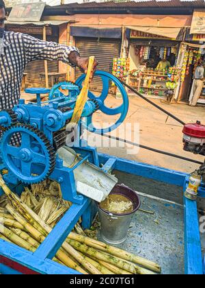 Street Side sugarcane Juice Maker, faisant le jus en écrasant les sucreries. Banque D'Images