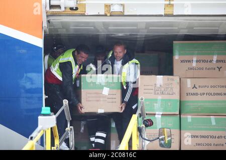 Calum Best (à droite) et Tamer Hassan aident à décharger des boîtes d'équipement de protection individuelle (EPI) d'un avion à l'aéroport Robin Hood de Doncaster, dans le Yorkshire du Sud. ??30,000 l'EPI a été donné à l'organisme de bienfaisance Mask Our Heroes, qui a été mis en place par l'entrepreneur Matthew McGahan à la suite de l'épidémie du coronavirus pour aider à fournir aux travailleurs de la santé et du NHS de première ligne l'équipement de protection dont ils ont besoin. Banque D'Images