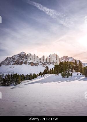 Paysage de montagne d'hiver avec neige, rochers et arbres au coucher du soleil dans les dolomites Banque D'Images