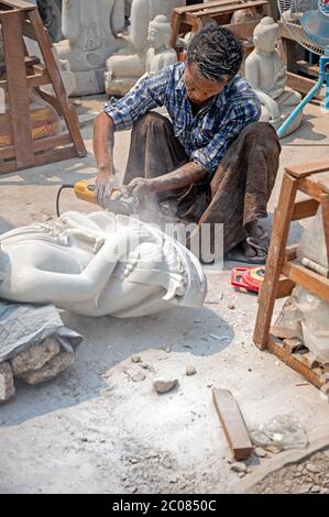 Un sculpteur sculptant une statue de Bouddha sur Kuauk s'assoit rue Tan dans le quartier Chanmyathazi de Mandalay, autour du temple de Mahamuni. Myanmar Banque D'Images