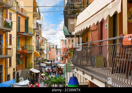 Les balcons donnent sur la rue principale de Manarola, une partie de l'Italie les Cinque Terre, en tant que touristes et habitants de profiter d'un après-midi. Banque D'Images