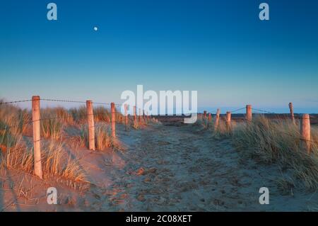 lumière chaude du coucher du soleil et lune sur le chemin de sable Banque D'Images