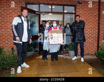 Calum Best (à gauche) et Tamer Hassan (à droite) dépose une boîte d'équipement de protection individuelle (EPI) à la maison de soins Royal à Rossington, qui a été livrée par avion à l'aéroport Robin Hood à Doncaster, dans le Yorkshire du Sud. ??30,000 l'EPI a été donné à l'organisme de bienfaisance Mask Our Heroes, qui a été mis en place par l'entrepreneur Matthew McGahan à la suite de l'épidémie du coronavirus pour aider à fournir aux travailleurs de la santé et du NHS de première ligne l'équipement de protection dont ils ont besoin. Banque D'Images