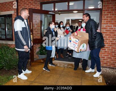 Calum Best (à gauche) et Tamer Hassan (à droite) dépose une boîte d'équipement de protection individuelle (EPI) à la maison de soins Royal à Rossington, qui a été livrée par avion à l'aéroport Robin Hood à Doncaster, dans le Yorkshire du Sud. ??30,000 l'EPI a été donné à l'organisme de bienfaisance Mask Our Heroes, qui a été mis en place par l'entrepreneur Matthew McGahan à la suite de l'épidémie du coronavirus pour aider à fournir aux travailleurs de la santé et du NHS de première ligne l'équipement de protection dont ils ont besoin. Banque D'Images