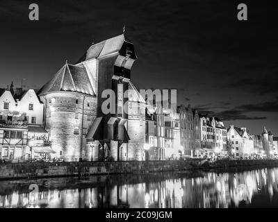 Gdansk la nuit avec une vieille grue et réflexion dans le fleuve Motlawa, Pologne. Image en noir et blanc. Banque D'Images