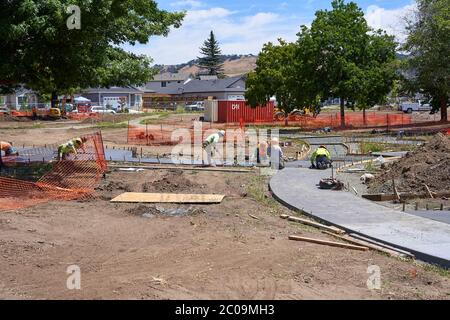 L'équipe de construction pose et nivelant des trottoirs en béton au parc Coffey de Santa Rosa, en Californie, qui a été dévasté par le feu Tubbs en 2017. Banque D'Images