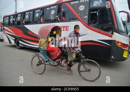 Les passagers portent un masque sur Rickshaw dans la rue de Sylhet, au Bangladesh Banque D'Images