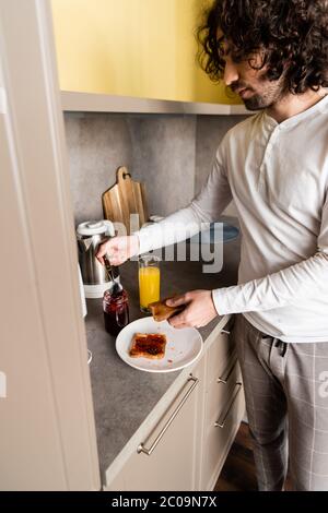 jeune homme en pyjama, bouclés pour le petit déjeuner Banque D'Images