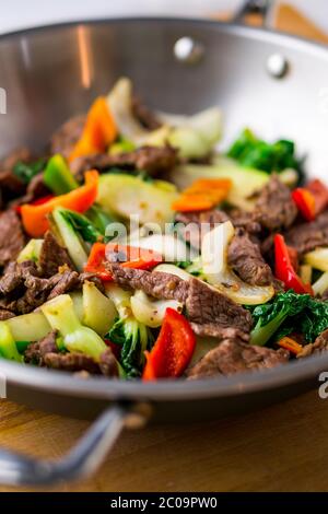 Légumes et bœuf sautés en bonne santé. Fait avec des steaks de flanc, des poivrons, des oignons et du bok choy sautés dans un wok asiatique. Banque D'Images