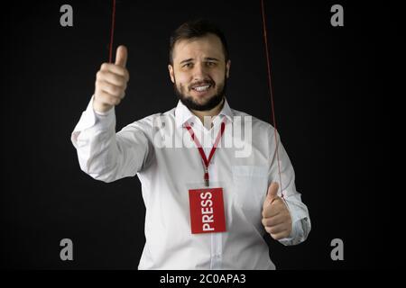 Journaliste au sourire faux montrant comme un signe, manipulation de médias indépendants Banque D'Images