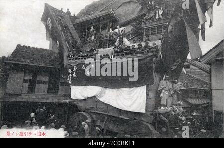 [ Japon des années 1920 - Festival religieux japonais ] — UN char hikiyama (曳山) au festival Seihakusai (青柏祭) à Nanao (七尾市), préfecture d'Ishikawa. Il s'agit de l'un des 33 festivals flottants de 18 préfectures autour du Japon qui ont été ajoutés à la liste du patrimoine culturel immatériel de l'UNESCO le 30 2016 novembre. Texte japonais: 木遣ニテ引き廻しノ景 carte postale du XXe siècle. Banque D'Images