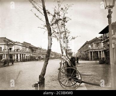 [ 1870s Japon - Tokyo Ginza ] — pousse-pousse sur l'avenue Ginza de Tokyo à la fin des années 1870. C'est maintenant l'intersection à Ginza 4-chome. Le bâtiment d'angle à gauche abritait les bureaux du quotidien Choya Shimbun. Le journal antigouvernemental pro-démocratique a été fondé en 1874 (Meiji 7) et a cessé en 1893 (Meiji 26). En 1894, l'horloger Kintaro Hattori a acheté le bâtiment et y a construit l'emblématique tour de l'horloge Hattori. Le célèbre bâtiment Wako se trouve maintenant à cet endroit. photographie d'albumine vintage du xixe siècle. Banque D'Images
