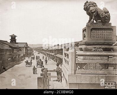 [ 1870s Japon - Gion, Kyoto ] — le quartier de divertissement de Gion à Kyoto vu des marches du sanctuaire de Yasaka. La rue est flanquée d'une multitude de maisons de thé où les clients peuvent apprécier la nourriture, la danse et la musique. La tour de gauche fait partie de l'école élémentaire Yasaka, créée en 1869 (Meiji 2). Les poteaux électriques ne sont pas encore en ligne. La compagnie d’électricité de Kyoto, Kyoto Dento Gaisha, a commencé ses activités en juillet 1889 (Meiji 22), et cette photo a donc été prise avant cette date. photographie d'albumine vintage du xixe siècle. Banque D'Images