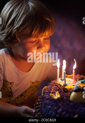 Petit garçon souffle les bougies pour son anniversaire Banque D'Images