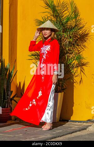 Jeune femme vietnamienne portant une robe Ao Dai dans les rues de Hoi an ville historique, patrimoine mondial de l'UNESCO. Banque D'Images