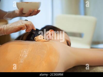 Belle femme détendue ayant le masque de corps en argile Banque D'Images