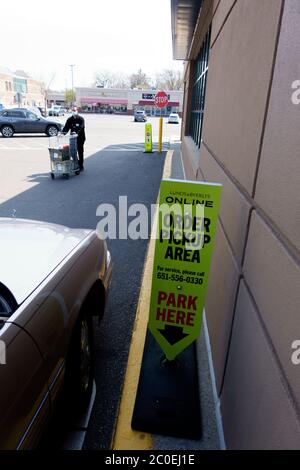 Le préposé à la livraison porte un masque lorsqu'il livrant une commande d'épicerie à une voiture dans la zone de ramassage en utilisant la distance sociale. St Paul Minnesota MN États-Unis Banque D'Images