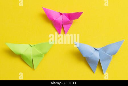 Papillons d'origami sur fond jaune Banque D'Images