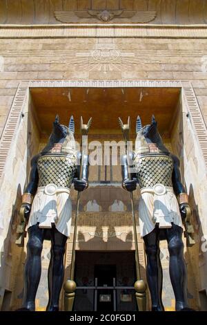 Deux statues énormes du dieu égyptien Anubis - le dieu de l'après-vie avec des matraques dans leurs mains gardent l'entrée de l'édifice. Vue de dessous. Banque D'Images