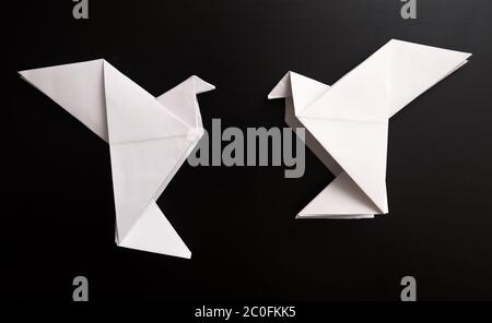 Deux colombes d'origami sur fond noir Banque D'Images