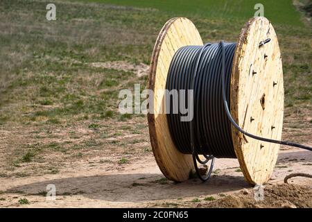 Concept de fourniture d'électricité pour les projets de construction. Bobine en bois avec câble d'alimentation. Banque D'Images