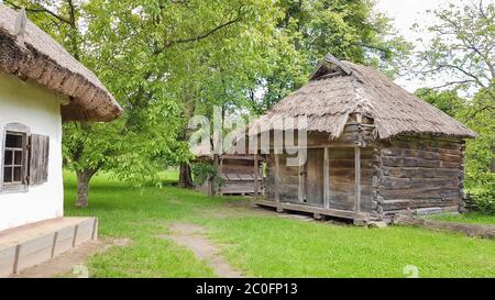 Ukraine, Kiev - 11 juin 2020. Ancienne maison paysanne ukrainienne ou grange en été avec un toit de chaume dans le village. Musée Pirogovo en plein air Banque D'Images