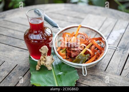 Le wedang uwuh se délasse en bouteilles de verre et de gingembre rouge, copeaux de bois de secang, citronnelle en tamis inoxydable, héritage de la médecine traditionnelle javanaise indonésienne traditionnelle Banque D'Images