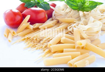 Des pâtes de différentes tailles avec de la tomate et basilic Banque D'Images