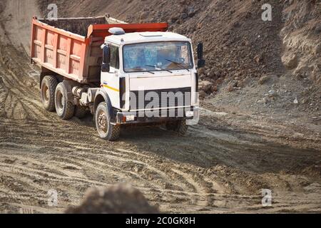 Un camion minier lourd de plusieurs tonnes exportant des minéraux de la mine à ciel ouvert. Concept de transport maritime et de protection de l'environnement et de la nature. Banque D'Images
