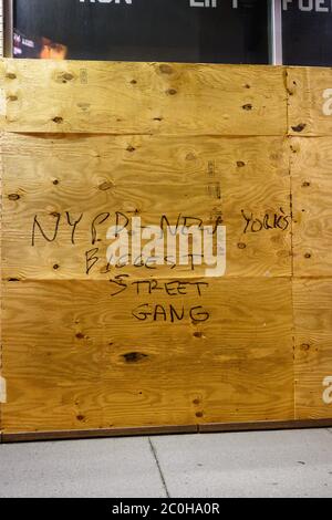 Graffiti dans le bas de Manhattan sur une fenêtre boarisée liseuse « NYPD - New York's Bigest Street Gang » Banque D'Images