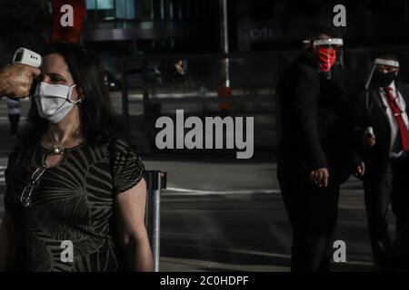 Sao Paulo. 11 juin 2020. Une femme a sa température corporelle mesurée avant d'entrer dans un centre commercial à Sao Paulo, Brésil, le 11 juin 2020. Sao Paulo a adopté une réouverture progressive des activités non essentielles et a ouvert les centres commerciaux de la ville. Le nombre total de cas confirmés de COVID-19 au Brésil a dépassé 800,000 et le nombre de décès a dépassé 40,000 jeudi, selon les médias locaux, citant les données du ministère de la Santé. Credit: Rahel Paprasso/Xinhua/Alamy Live News Banque D'Images