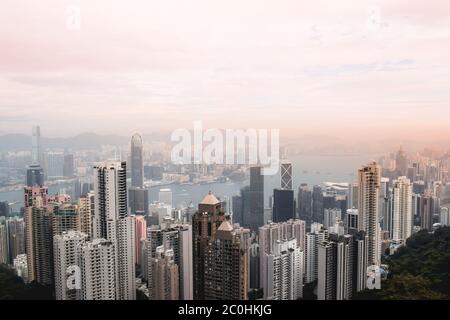 Magnifique vue sur le coucher de soleil rose sur les gratte-ciel de Hong Kong et le port Victoria depuis le Peak Banque D'Images