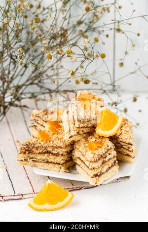 Gâteau maison ?ut aux morceaux avec zeste d'agrumes confits décoré de tranches d'orange servi sur une assiette blanche Banque D'Images