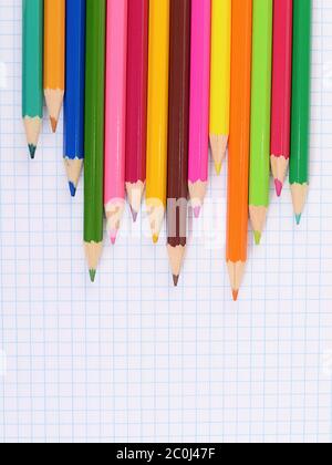 colorer les crayons contre une feuille en cage Banque D'Images